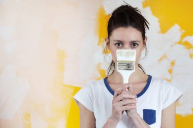 Bir fırça ile genç bir kadın ressam Portresi, ev yenileme ve duvar boyama kavramı