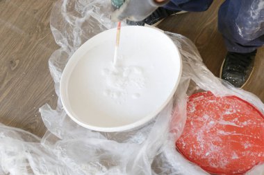 Adam iç duvarlar için beyaz boya hazırlanıyor