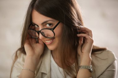 Gözlük takan doğal güzel genç bir kadının stüdyo portresini kapatın