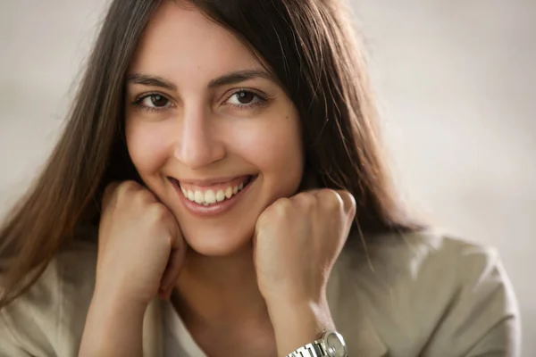 Close up studio portrait of a naturally beautiful young woman smiling  at the camera