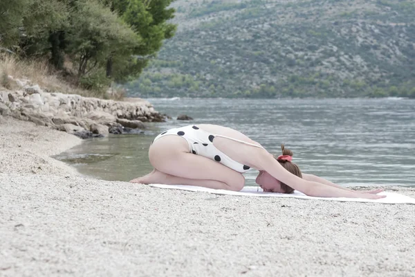 genç kadın sahilde Yoga uygulamak