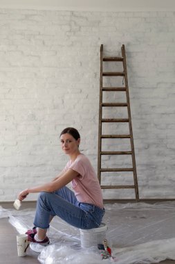 Genç bir kadın evini dekore ederken kahve molası veriyor. Büyük işten önce dinleniyor.