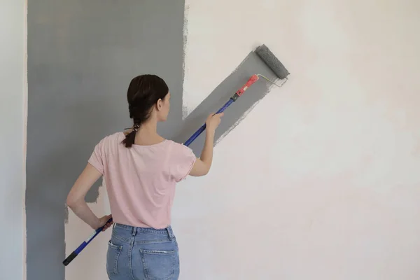 Kobieta Malując Szarą Farbą Białej Ścianie — Zdjęcie stockowe