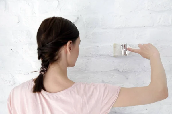 女人用油漆刷画白砖墙 — 图库照片