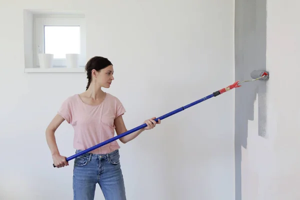 Mujer Pintando Con Pintura Gris Sobre Una Pared Blanca — Foto de Stock