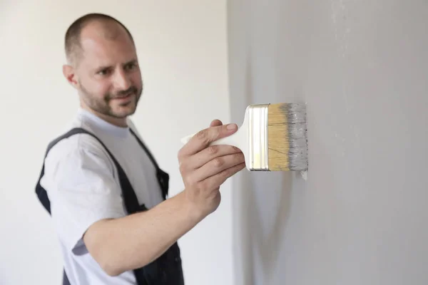 Hombre Pintando Con Pincel Sobre Una Pared Gris — Foto de Stock