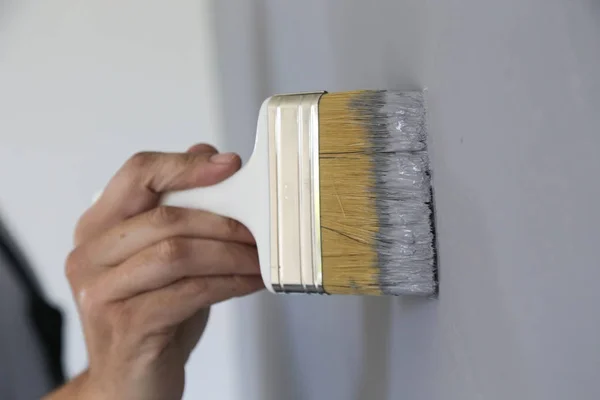 Hombre Pintando Con Pincel Sobre Una Pared Gris —  Fotos de Stock