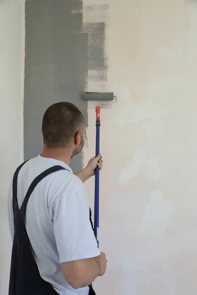 Mann Malte Mit Grauer Farbe Über Eine Weiße Wand — Stockfoto