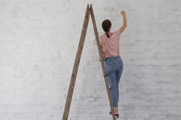 Mulher Pintando Uma Parede Tijolo Branco Com Pincel Pintura — Fotografia de Stock