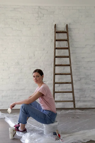 Genç bir kadın evini dekore ederken kahve molası veriyor. Büyük işten önce dinleniyor.