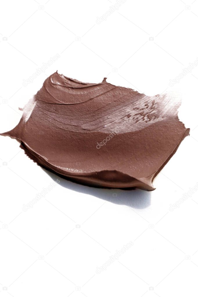 Brown creamy cosmetic sample isolated on white