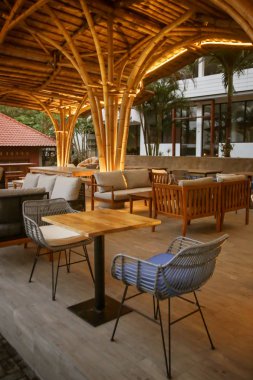 Akşam saatlerinde beyaz masalar ve rattan sandalyeile Cafe, rahat tarzı, hiçbir kişi