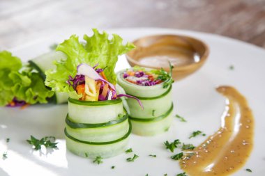 Sebzeler ve fıstık sosu ile ince dilimlenmiş çiğ kabak rulo, organik vejetaryen sağlıklı atıştırmalık