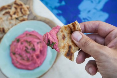 Taze pişmiş naan ekmek parçaları ile pancar humus