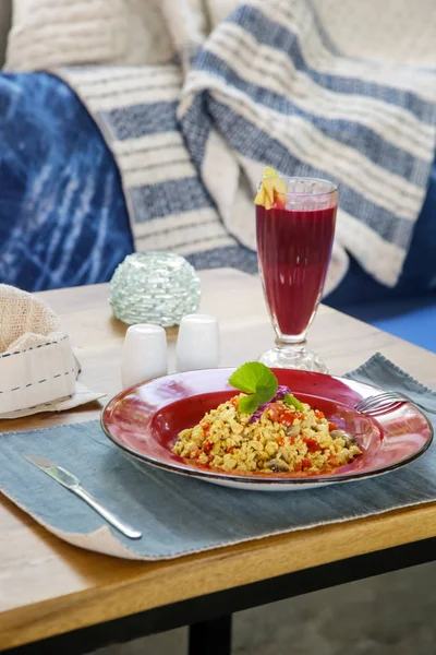 Tofu scramble and beetroot detox drink served on the restaurant table, healthy casual dining concept