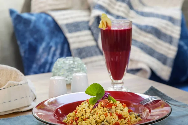 Tofu scramble and beetroot detox drink served on the restaurant table, healthy casual dining concept