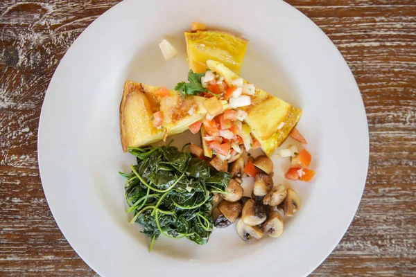 Spanish Potato Tortilla served with mushrooms and spinach, casual dining restaurant food