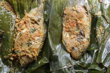 Geleneksel Endonezya mutfağı. Muz yaprağında servis edilen baharatlı ızgara balık
