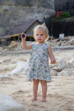 Sahilde bulunan bir plastik parçasını tutan çocuk. Kumsaldaki plastik çöp. Plastik kirlilik kavramı. 