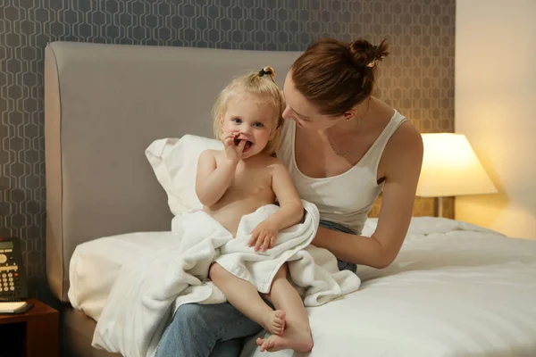 Mum and her baby girl spending time together after bathing, baby preparation for a good night's sleep.