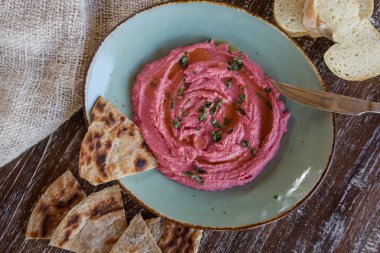 Taze pişmiş naan ekmek parçaları ile pancar humus