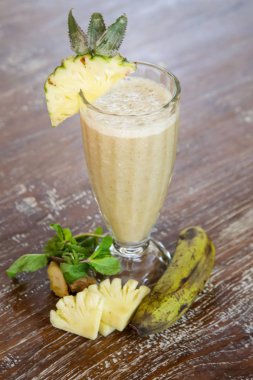 Etrafında malzemelerle cam Taze organik muz ananas smoothie