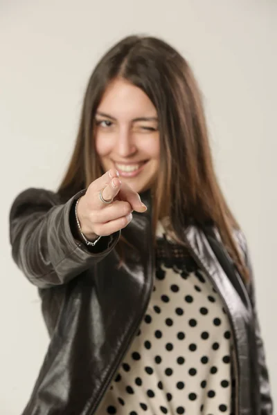 Woman pointing pistol-like handgun sign, hand gesture studio shot