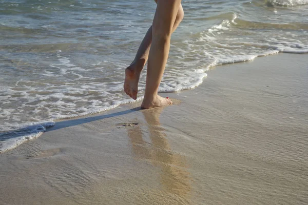走在热带沙滩上的女人 双腿和海浪的特写图像 — 图库照片