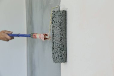 Boya rulosu. Beyaz bir duvar üzerinde gri boya ile boyama