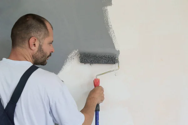 Hombre Pintando Con Pintura Gris Sobre Una Pared Blanca — Foto de Stock