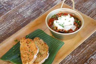 Domates soslu haşlanmış yumurta ev yapımı siyah ekmek ile servis