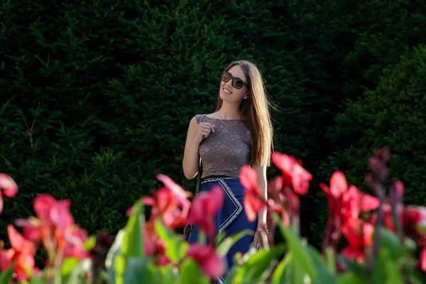 Ευτυχής Νεαρή Γυναίκα Στέκεται Ένα Πάρκο Κοντά Στα Λουλούδια Ειλικρινής — Φωτογραφία Αρχείου