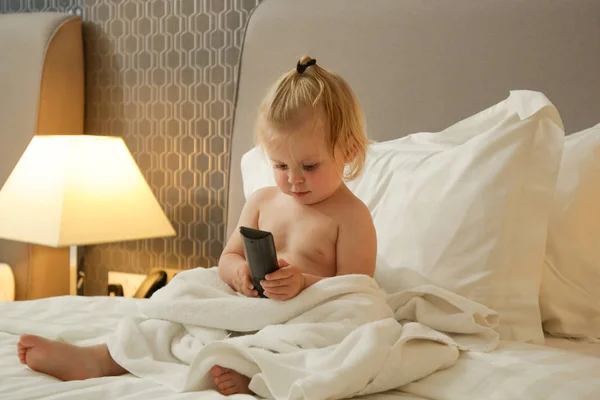 Симпатична Дівчинка Малюк Сидить Ліжку Тримає Телевізійний Пульт Дистанційного Керування — стокове фото