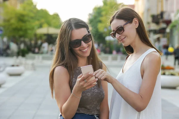 Dva Přátelé Dívají Mobil Dvě Dívky Městě — Stock fotografie