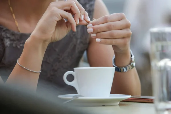 カフェに座ってコーヒーに砂糖を加えた若い美しい女性の肖像 — ストック写真