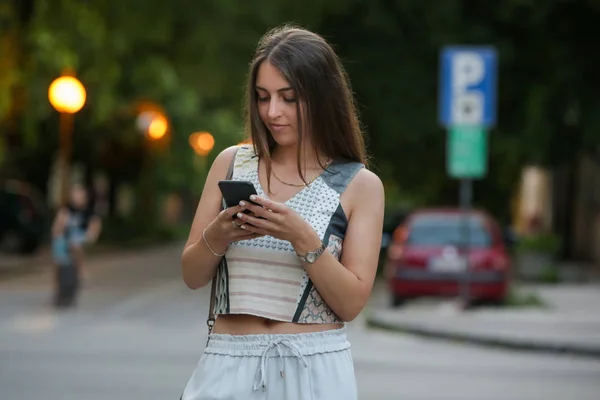 路上でスマートフォンにメッセージを入力する女性 携帯電話を使用して街の若いかわいい女の子 — ストック写真