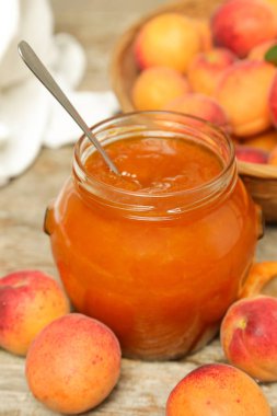 Ahşap arka planda Kayısı reçeli ve taze kayısı kavanozu