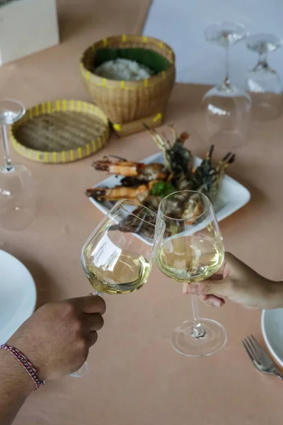 A chin-chin with white wine glasses over a restaurant table