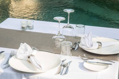 Boş tabaklarla öğle yemeği için açık beyaz masa kuruldu