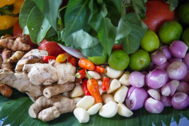 Taze çeşniler, kireç, zencefil kökleri, sarımsak, arpacık soğanı ve kırmızı biber bir yığın