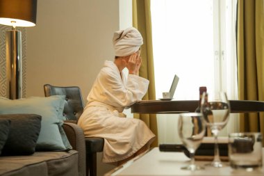 Dizüstü bilgisayarın önünde kahve içen, önceki geceden sonra toparlanmaya çalışan ve gün öncesinden güne hazır lansa, çok fazla içtikten sonra sabah, akşamdan kalma kavramıyla başa çıkmaya çalışan, boşa harcanan kadın