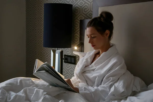 Όμορφη Νεαρή Γυναίκα Διαβάζοντας Ένα Βιβλίο Στο Κρεβάτι — Φωτογραφία Αρχείου