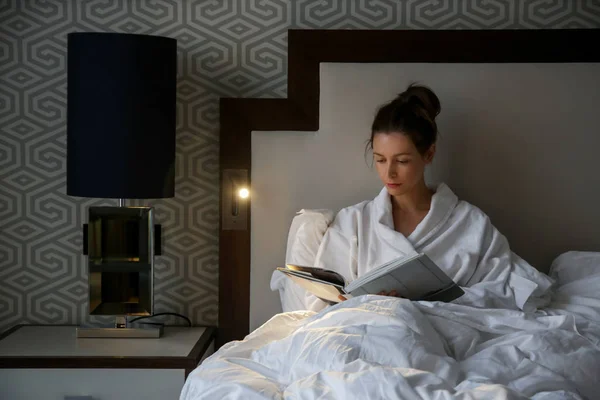 Όμορφη Νεαρή Γυναίκα Διαβάζοντας Ένα Βιβλίο Στο Κρεβάτι — Φωτογραφία Αρχείου