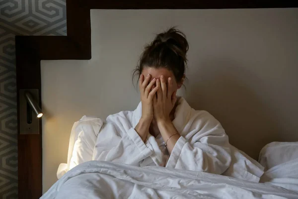 年轻的悲伤的女人坐在床上 关系困难 偏头痛或晨病的概念 — 图库照片