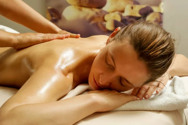 Oil back massage, a woman in the spa having aromatherapy massage with essential oil