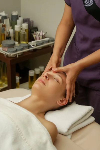 Face massage, a woman in the spa having anti-age face massage