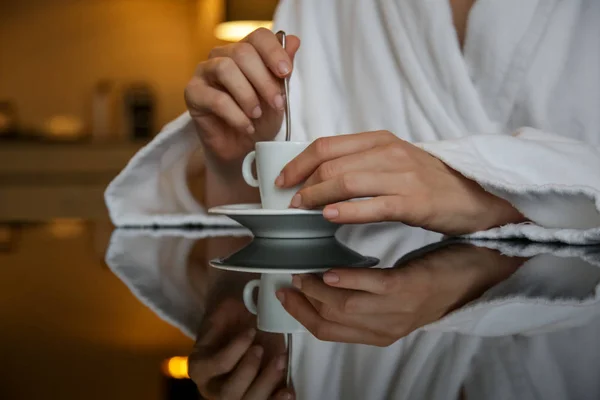 反射と黒いテーブルの上にコーヒー カップと手を持っている女性 — ストック写真