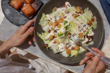 Öğle yemeğinde ton balığı sezar salatası olan kadın