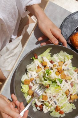 Öğle yemeğinde ton balığı sezar salatası olan kadın