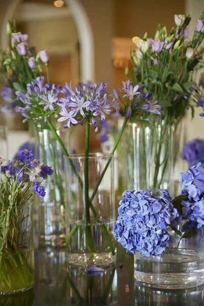  Güzel masanın üzerinde çiçek cam tencere mor çiçekler düzenlenmiştir. Zarif çiçek aranjmanı.